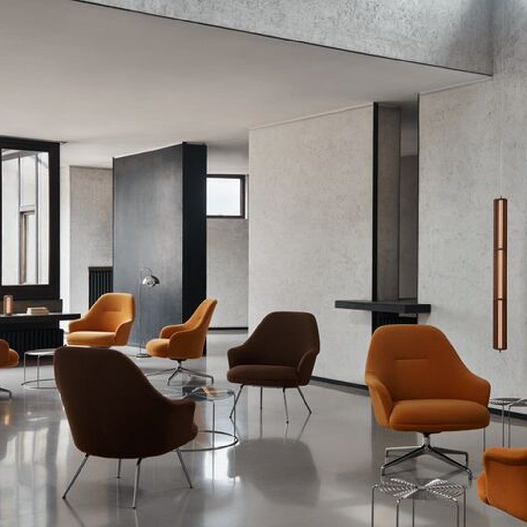 Modern lounge with warm orange and rich brown chairs against a sleek gray and black backdrop. Sophisticated color palette.
