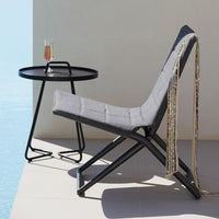 Gray fabric lounge chair with a sleek black metal frame, styled against a light background, featuring minimalist design elements.
