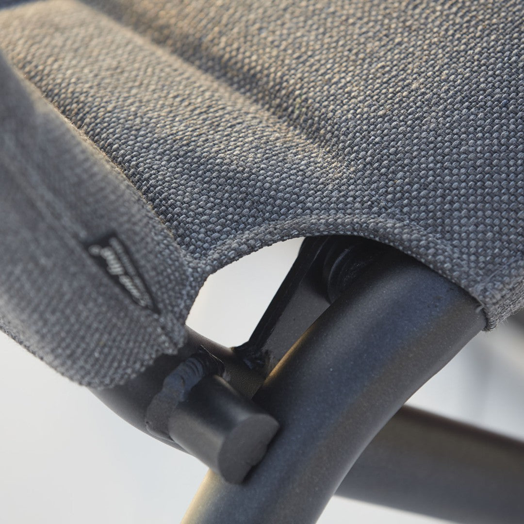 Close-up of a textured gray fabric with subtle patterns, highlighting the black metal frame and stitching details.