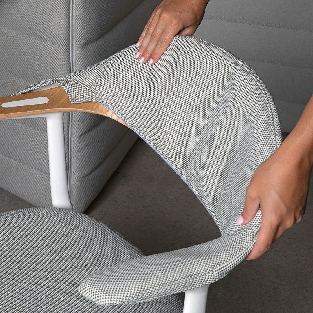 Gray fabric chair with subtle houndstooth pattern, complemented by natural wood accents and sleek white legs.