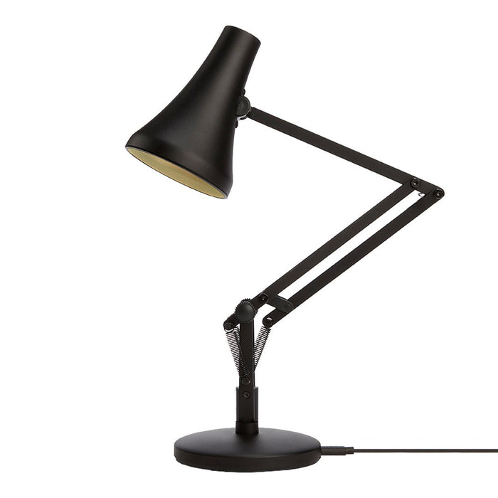 Black desk lamp with a sleek, modern design and a matte finish, featuring a gold interior for a stylish contrast.
