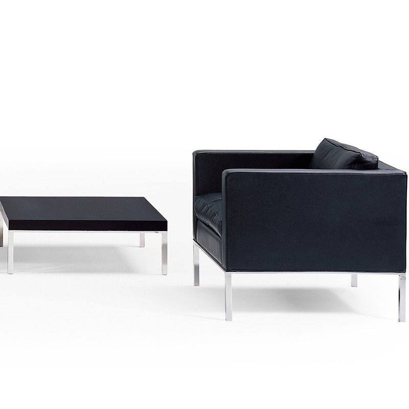 Black modern sofa and matching coffee table with sleek chrome legs and minimalist design. Elegant and contemporary aesthetic.
