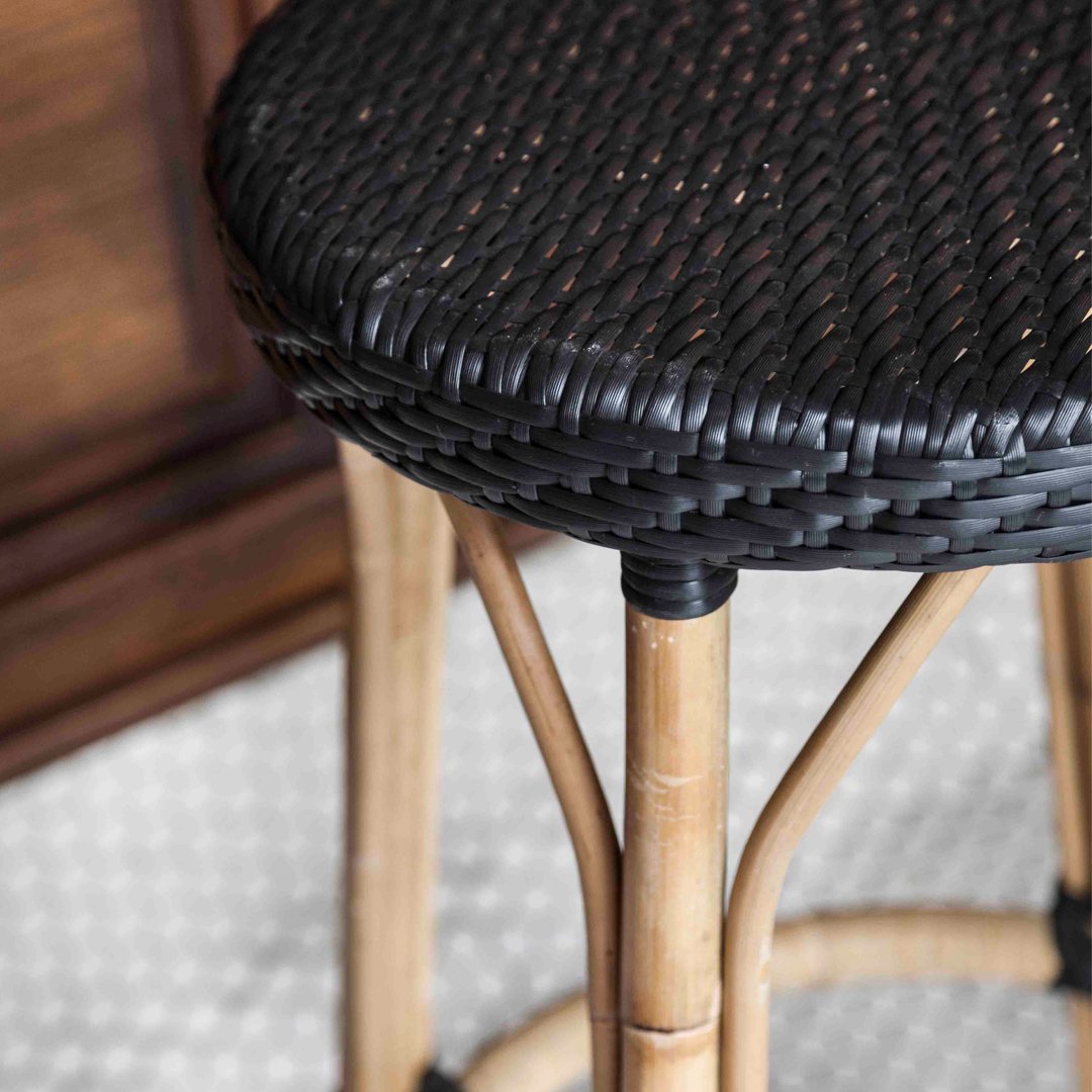 Black woven seat on a natural bamboo bar stool, featuring a modern, textured design against a light backdrop.