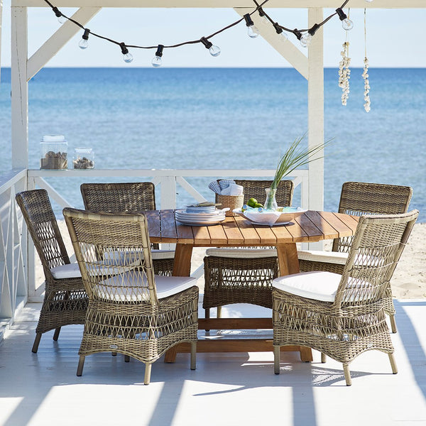 "Coastal dining set with natural wicker chairs and a wooden table, featuring neutral tones and subtle textures."