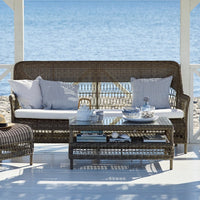 Coastal wicker sofa set with gray cushions and striped patterns, perfect for outdoor relaxation by the water.