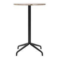Round beige table top with a textured finish, supported by a sleek black metal base. Modern design and neutral colors.