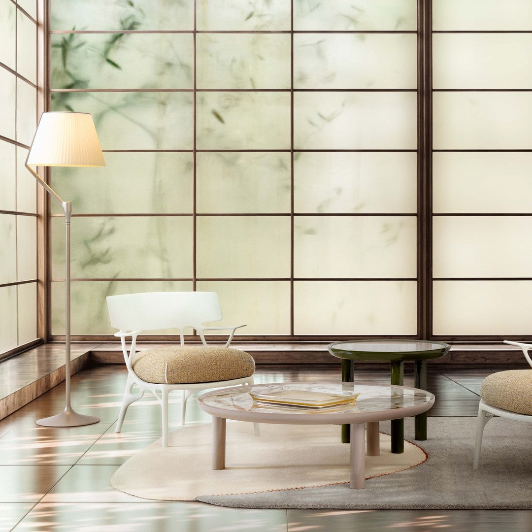 Elegant living room with soft green walls, beige and white furniture, and subtle floral patterns on light surfaces.