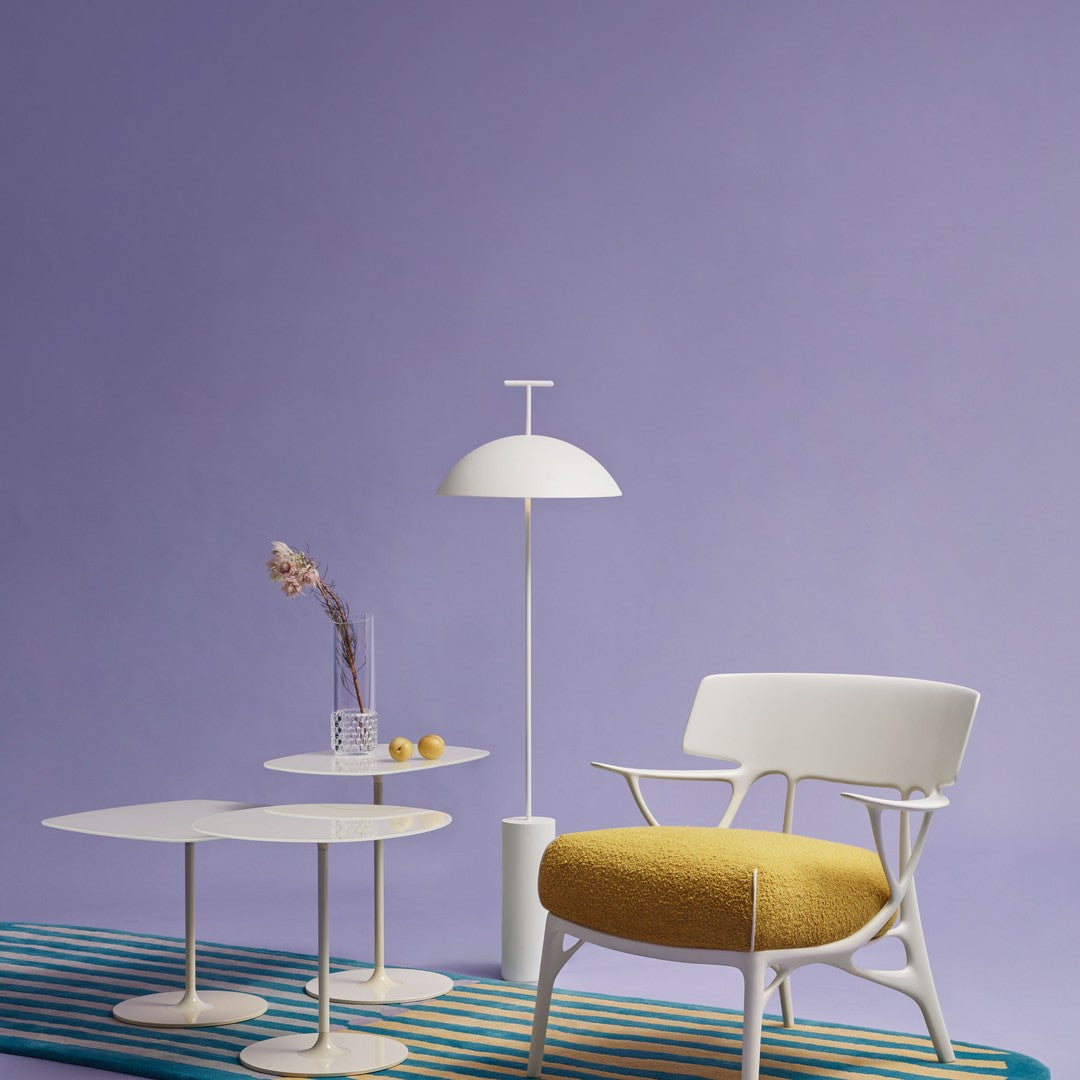 Elegant white furniture against a soft purple wall, featuring a yellow cushion and striped blue rug.