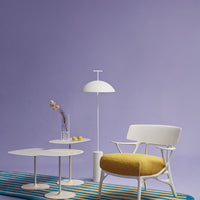 Elegant white furniture against a soft purple wall, featuring a yellow cushion and striped blue rug.