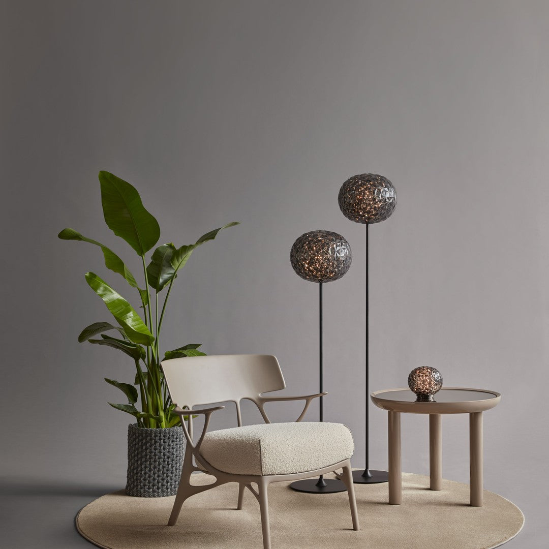 Stylish neutral tones with earthy green leaves, textured gray lamp shades, and soft beige furniture elements.