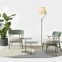 Green chairs with beige cushions on a multi-colored rug featuring soft gray, cream, and brown patterns.