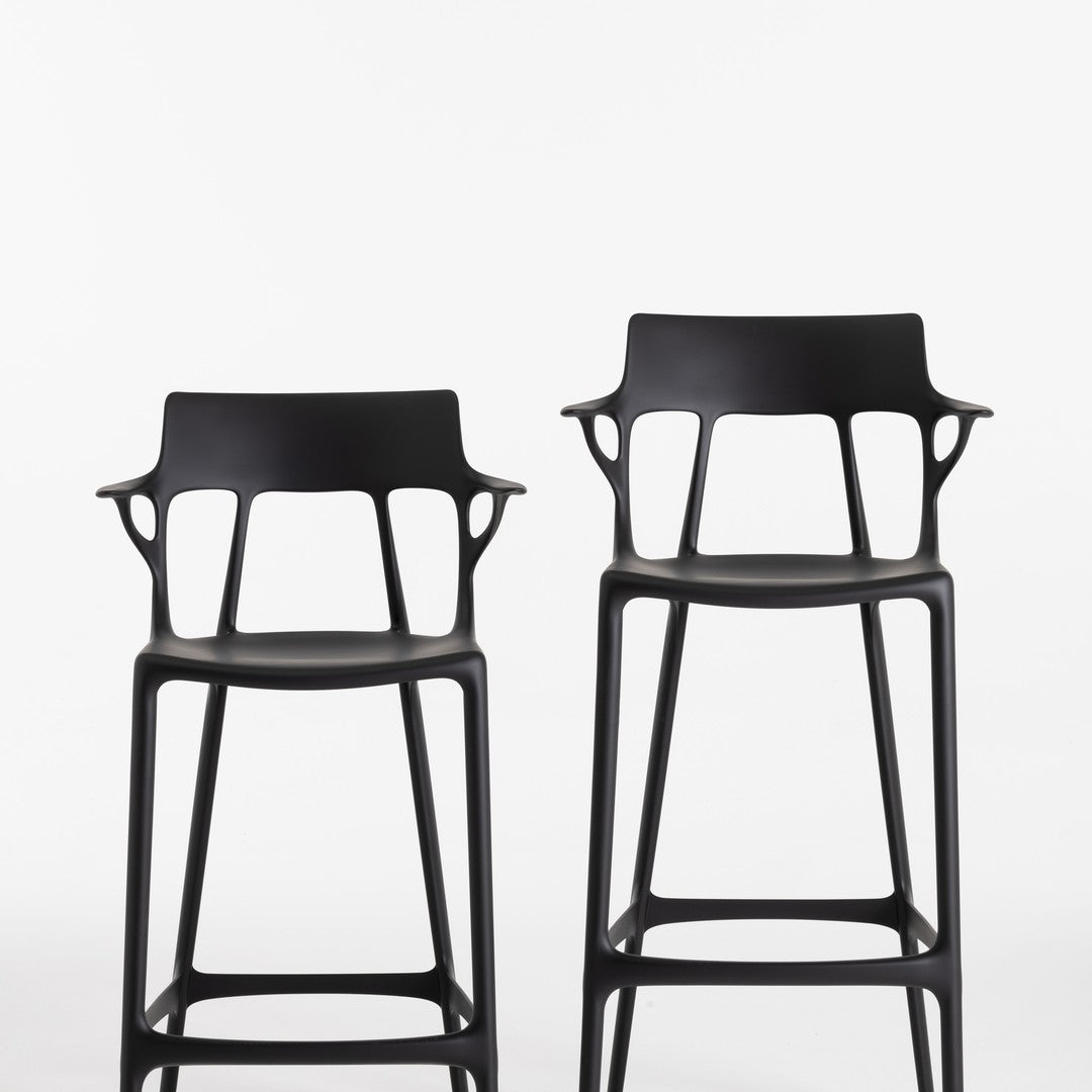 Sleek black bar stools with modern cut-out patterns, showcasing a minimalist design and contemporary style.