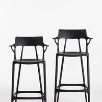 Sleek black bar stools with modern cut-out patterns, showcasing a minimalist design and contemporary style.
