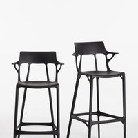 Set of two sleek black bar stools with unique cut-out patterns, perfect for modern decor.