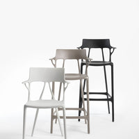Three modern bar stools in white, taupe, and black, showcasing sleek designs with open back patterns.