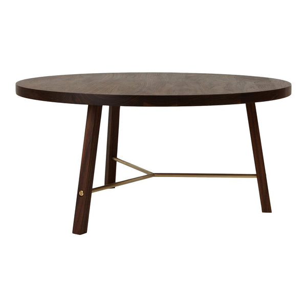 Round dark wood table with a smooth surface and contrasting brass accents on modern wooden legs.