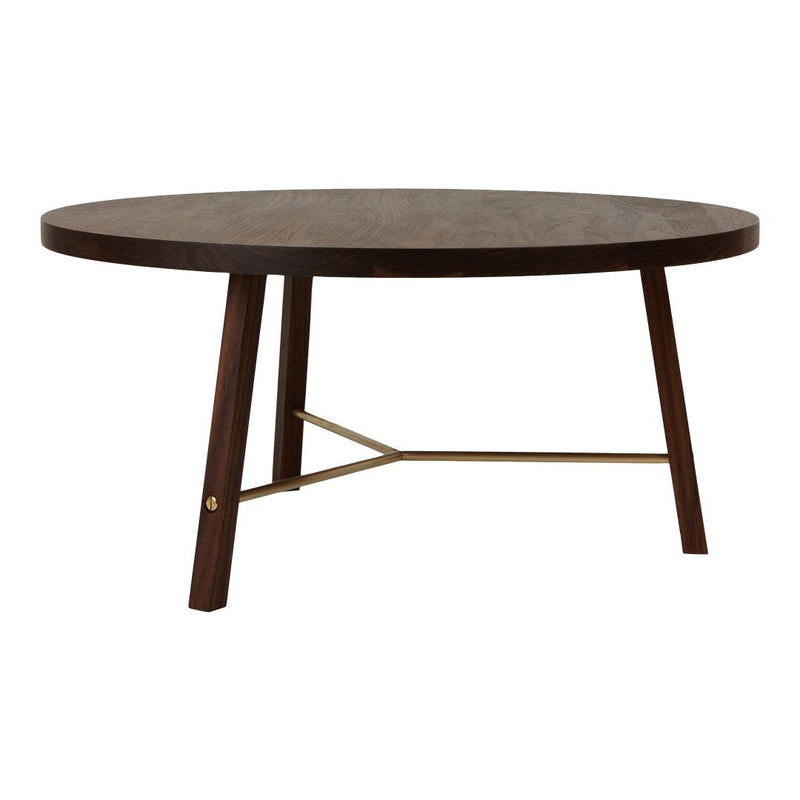 Round dark wood table with a smooth surface and contrasting brass accents on modern wooden legs.