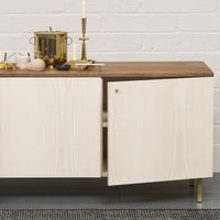 Light wood cabinet with a smooth natural finish and a contrasting rich walnut top, accented by gold hardware.