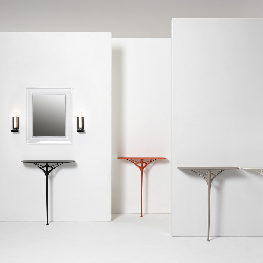 Black, orange, light gray, and beige console tables against a minimalist white backdrop, featuring modern geometric patterns.