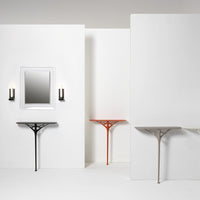 Black, orange, light gray, and beige console tables against a minimalist white backdrop, featuring modern geometric patterns.