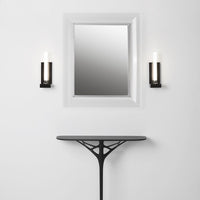 Black sconces with white light beside a sleek black table against a minimalist white wall and mirrored frame.
