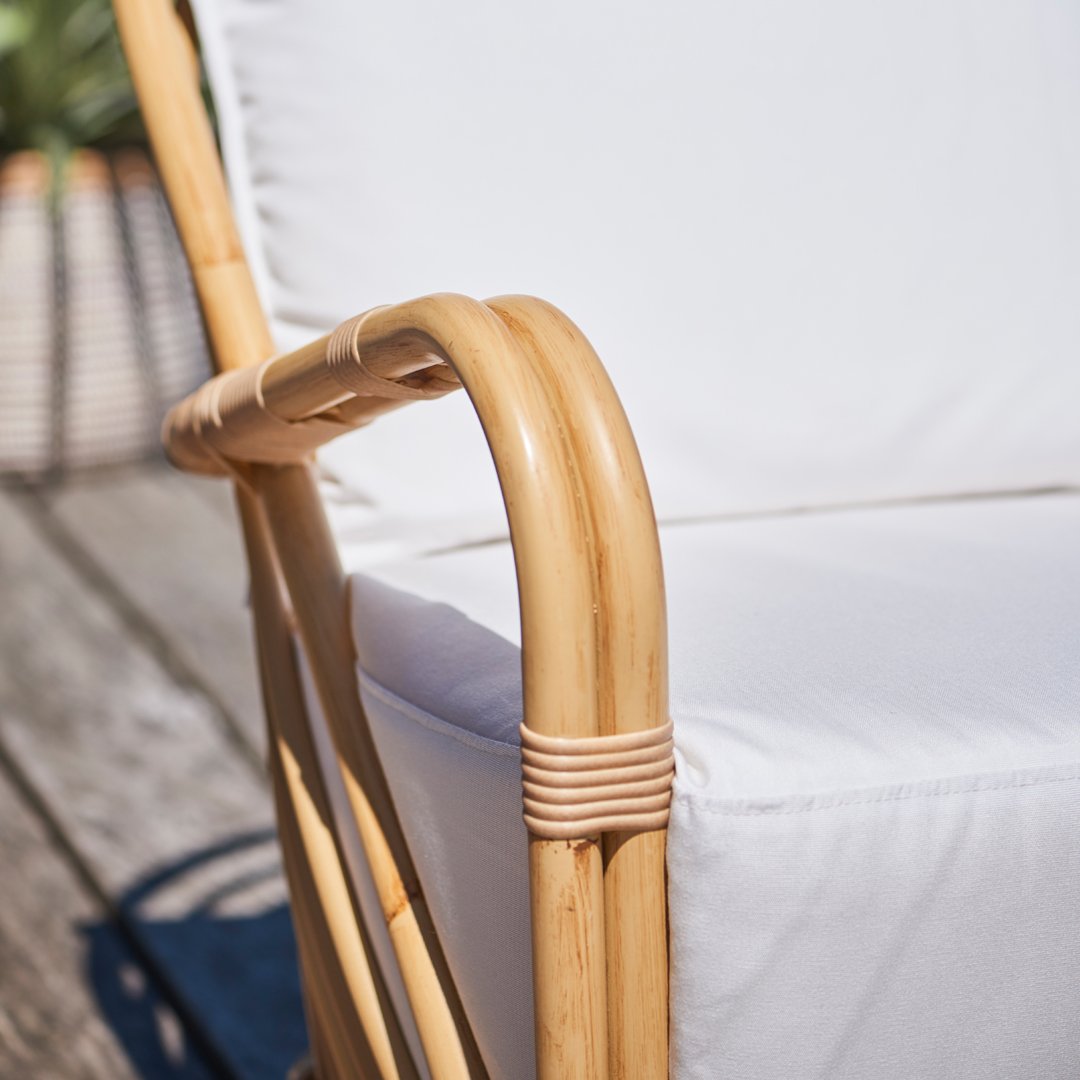 "Natural bamboo chair with white cushion, showcasing a clean, minimalist design."
