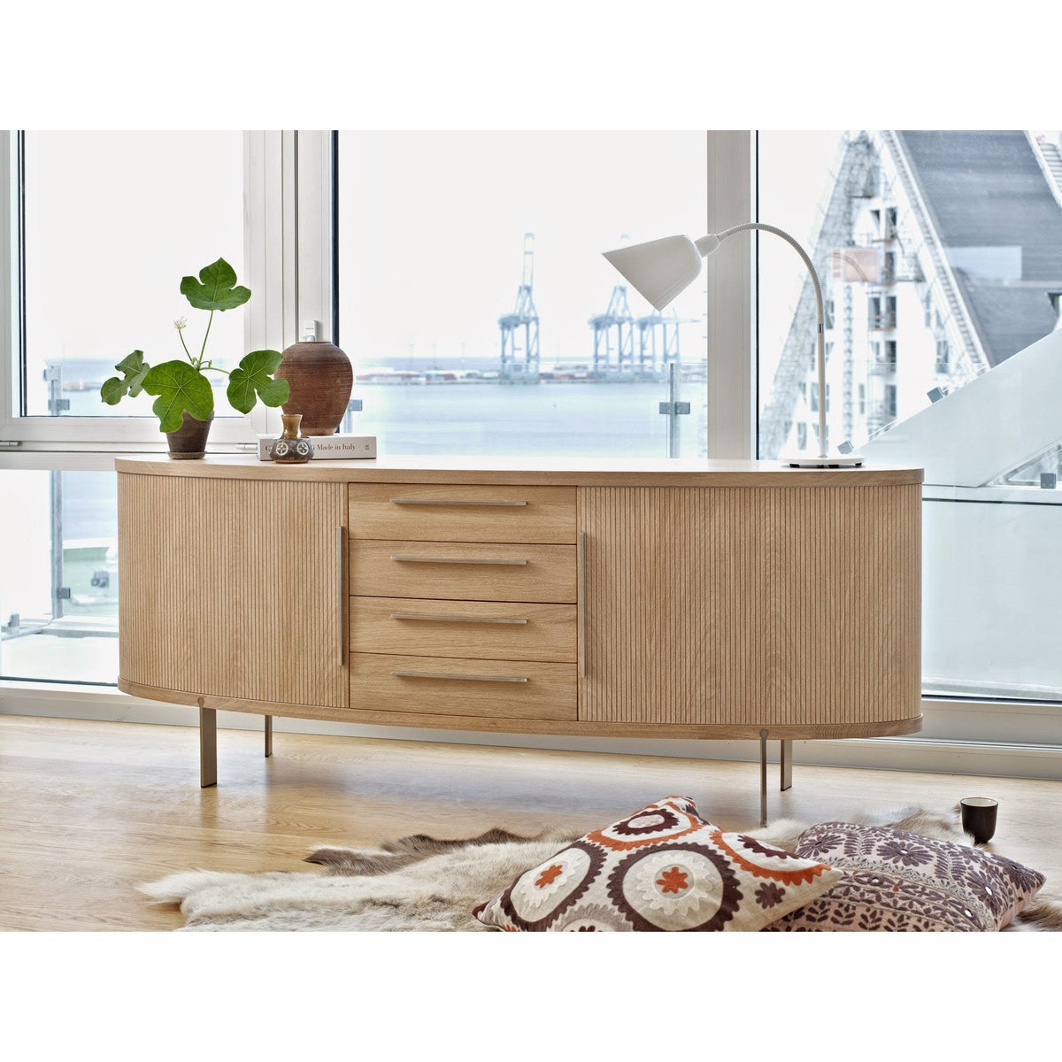 Light oak buffet with sleek lines, showcasing natural wood grain and minimalist design against a bright, modern backdrop.