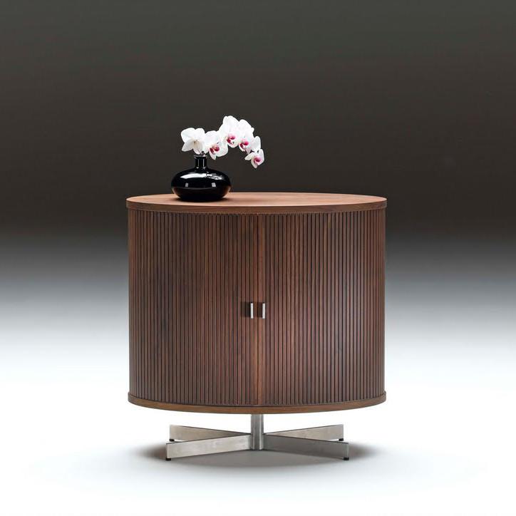 Round wooden side table in rich walnut finish with vertical grooves, accented by a chrome base and elegant vase.