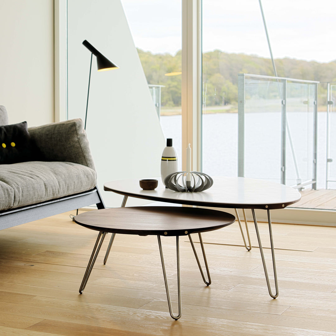 Modern coffee tables in natural wood tones with sleek black accents and minimalist design against a bright, airy background.