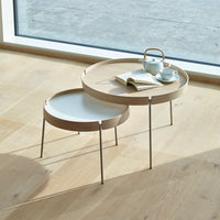 Modern round coffee tables with light wood trim and white surfaces, elegantly layered for a stylish look.