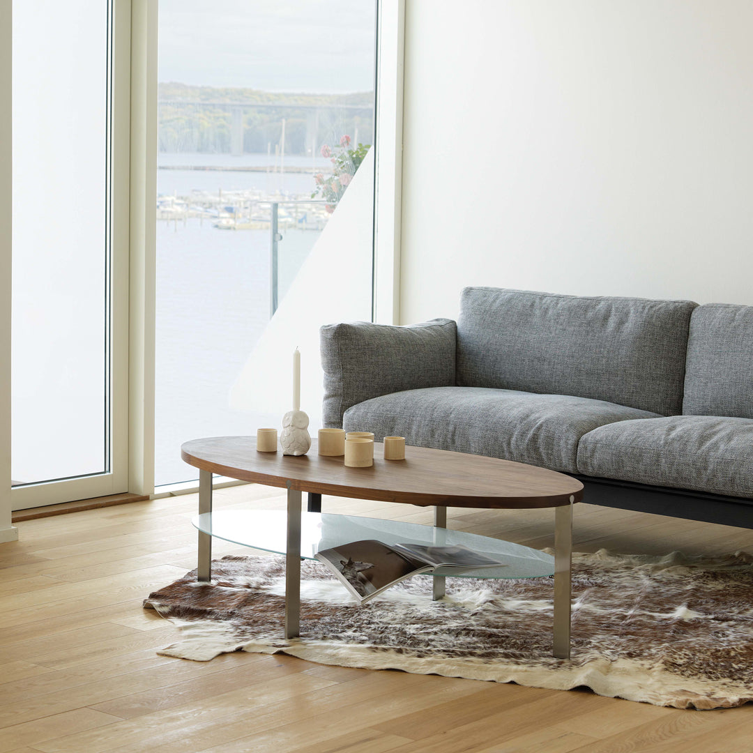 Wooden coffee table with a sleek, modern design, featuring light brown tones and a soft, patterned area rug.