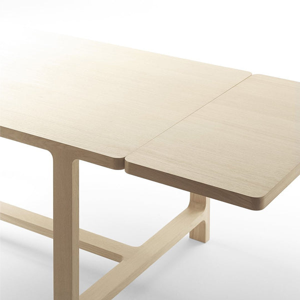 Light-colored wooden table with a smooth finish and contemporary design, featuring a subtle natural grain pattern.