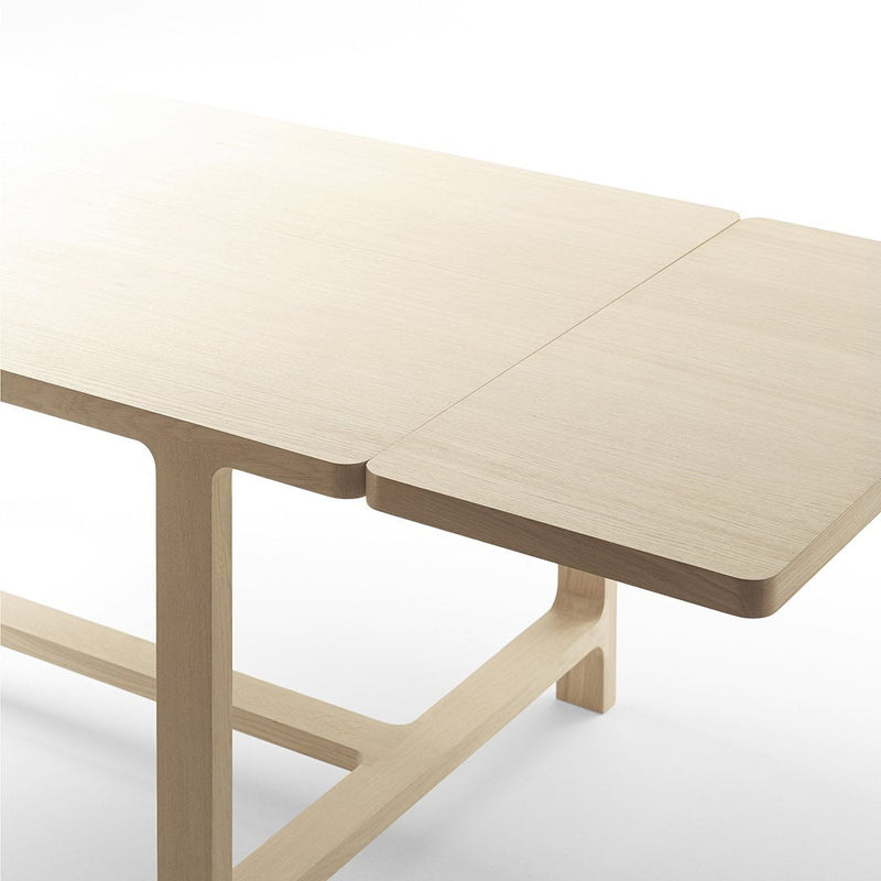 Light-colored wooden table with a smooth finish and contemporary design, featuring a subtle natural grain pattern.