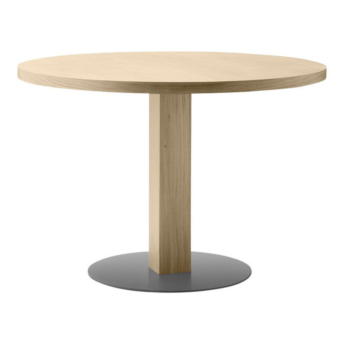 Round wooden table with a natural oak finish and a sleek, contrasting black metal base. Simple and modern design.