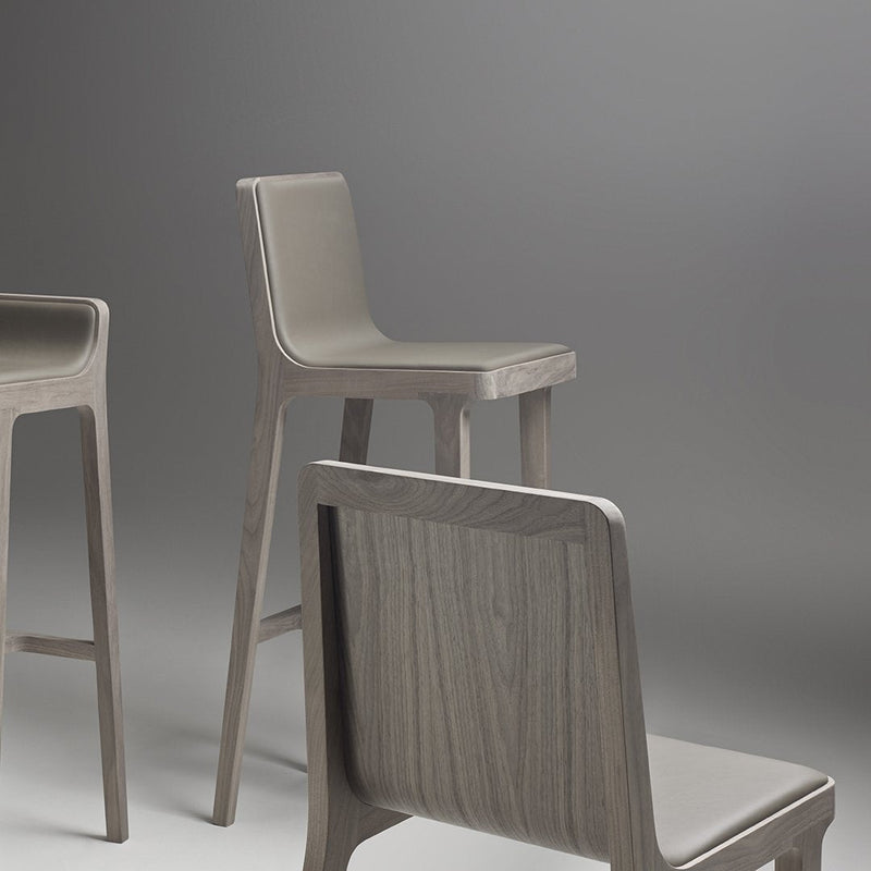 Stylish gray wooden stools with a smooth finish and simple, modern design against a soft gradient background.