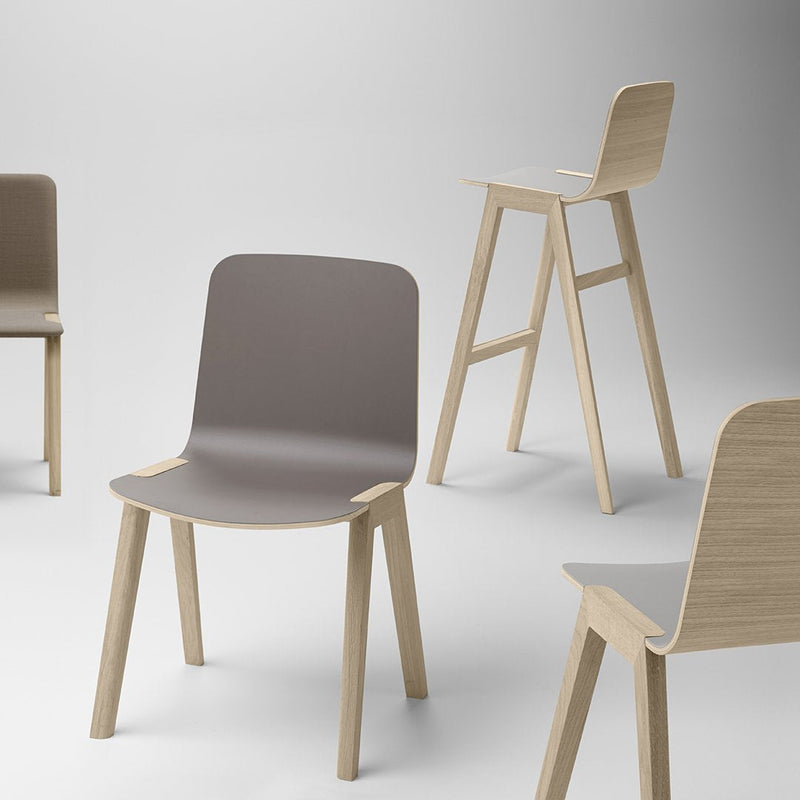 Modern minimalistic chairs featuring a gray seat and light wood legs, showcasing a sleek design and neutral palette.