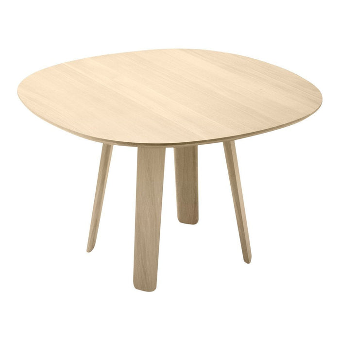 Light wood round dining table with a smooth surface and tapered legs, showcasing natural grain pattern.