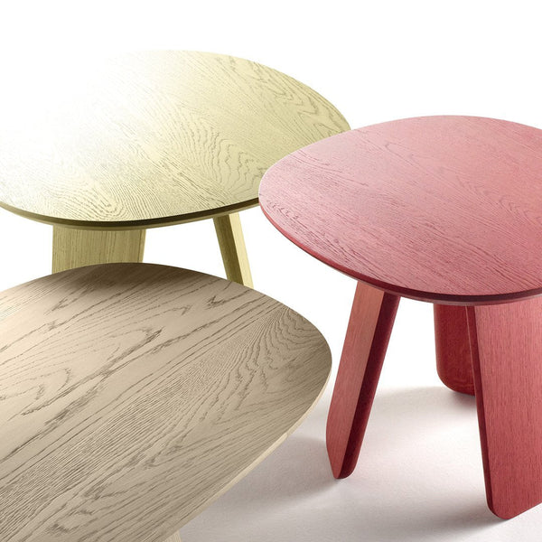 Three round tables in soft green, pink, and light beige with natural wood grain patterns.