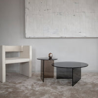 Modern coffee tables in sleek black glass, featuring minimalist design and elegant geometric shapes against a neutral backdrop.