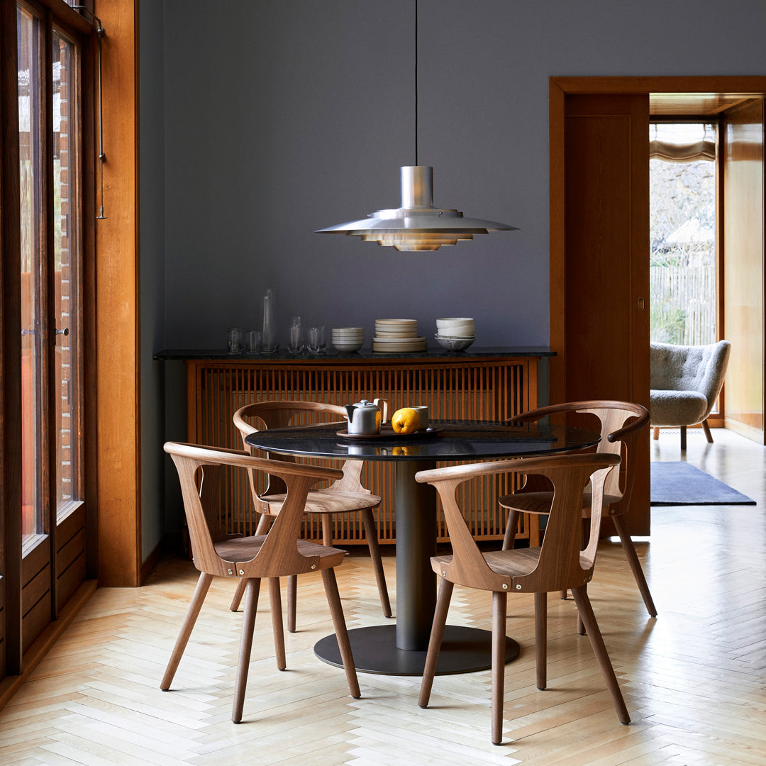 Modern dining set featuring warm wood tones, sleek black table, and soft beige chairs in a stylish interior space.