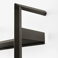Matte black wall shelf with sleek, angular design and minimalistic pattern for modern decor.