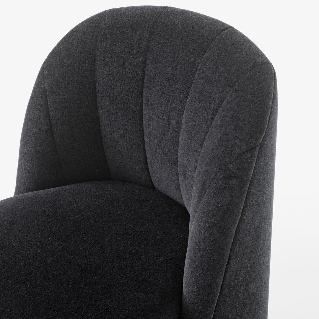Close-up of a textured dark gray upholstered chair with a curved, padded design and vertical seam patterns.