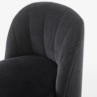 Close-up of a textured dark gray upholstered chair with a curved, padded design and vertical seam patterns.