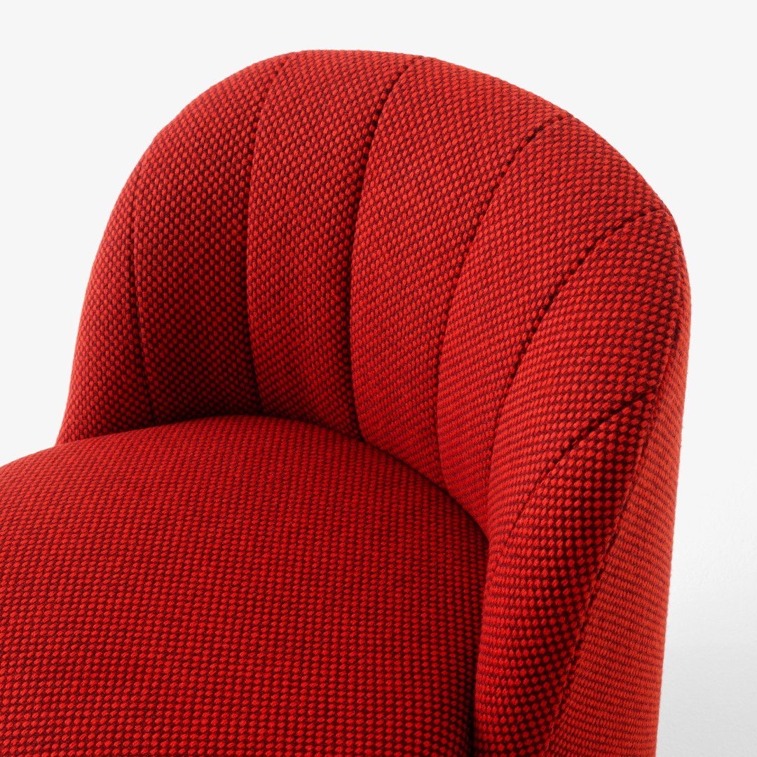 Red upholstered chair with textured, patterned fabric featuring a bold, vibrant hue.