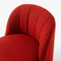 Red upholstered chair with textured, patterned fabric featuring a bold, vibrant hue.