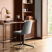 Gray upholstered chair with a sleek design, complemented by a black metal base and a rich wood backdrop.