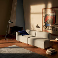 Light gray modular sofa with a plush navy throw, set against warm wood flooring and a soft gray area rug.