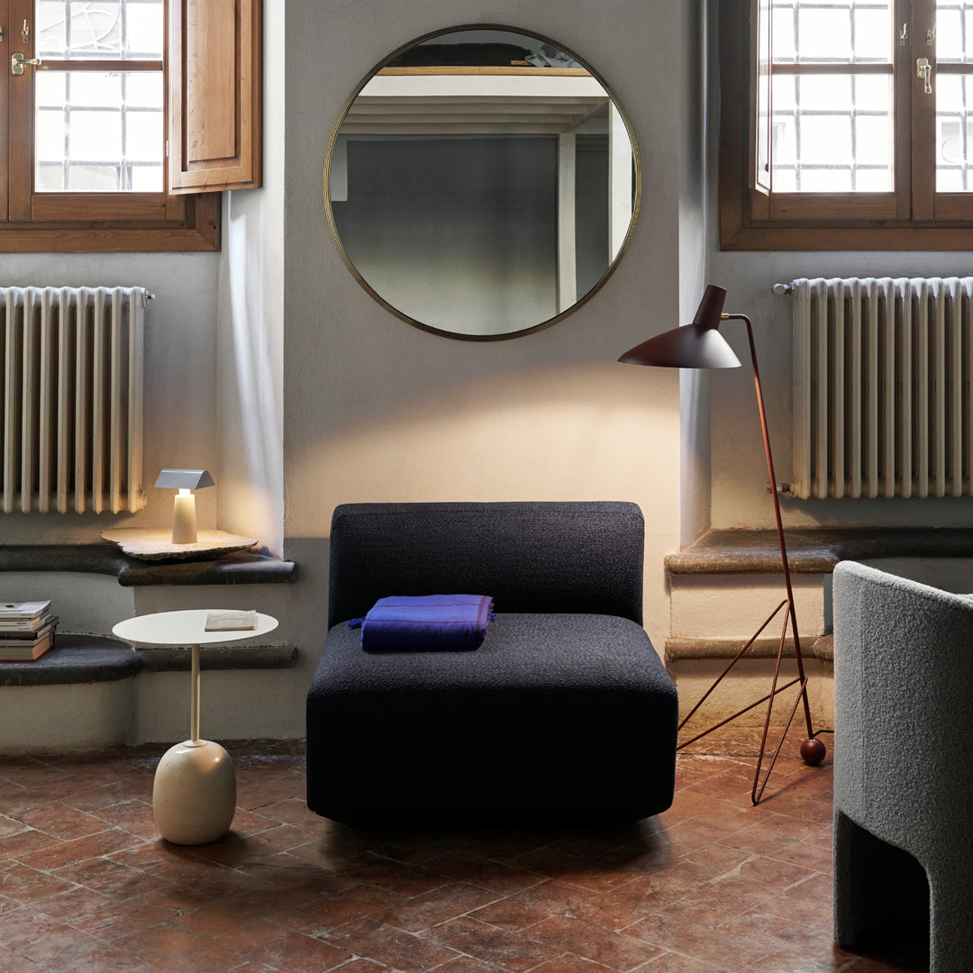 Dark navy chair with a solid fabric pattern, complemented by a blue throw and neutral-toned decor elements.