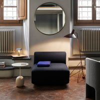 Dark navy chair with a solid fabric pattern, complemented by a blue throw and neutral-toned decor elements.