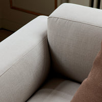 Light gray upholstery with a textured finish, complemented by a brown throw pillow for added contrast.